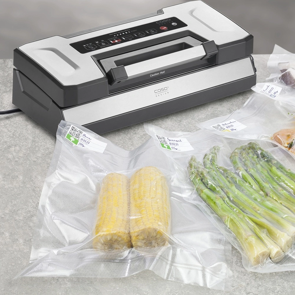Vakuumiergerät mit Mais, Spargel und Fleisch in Beuteln