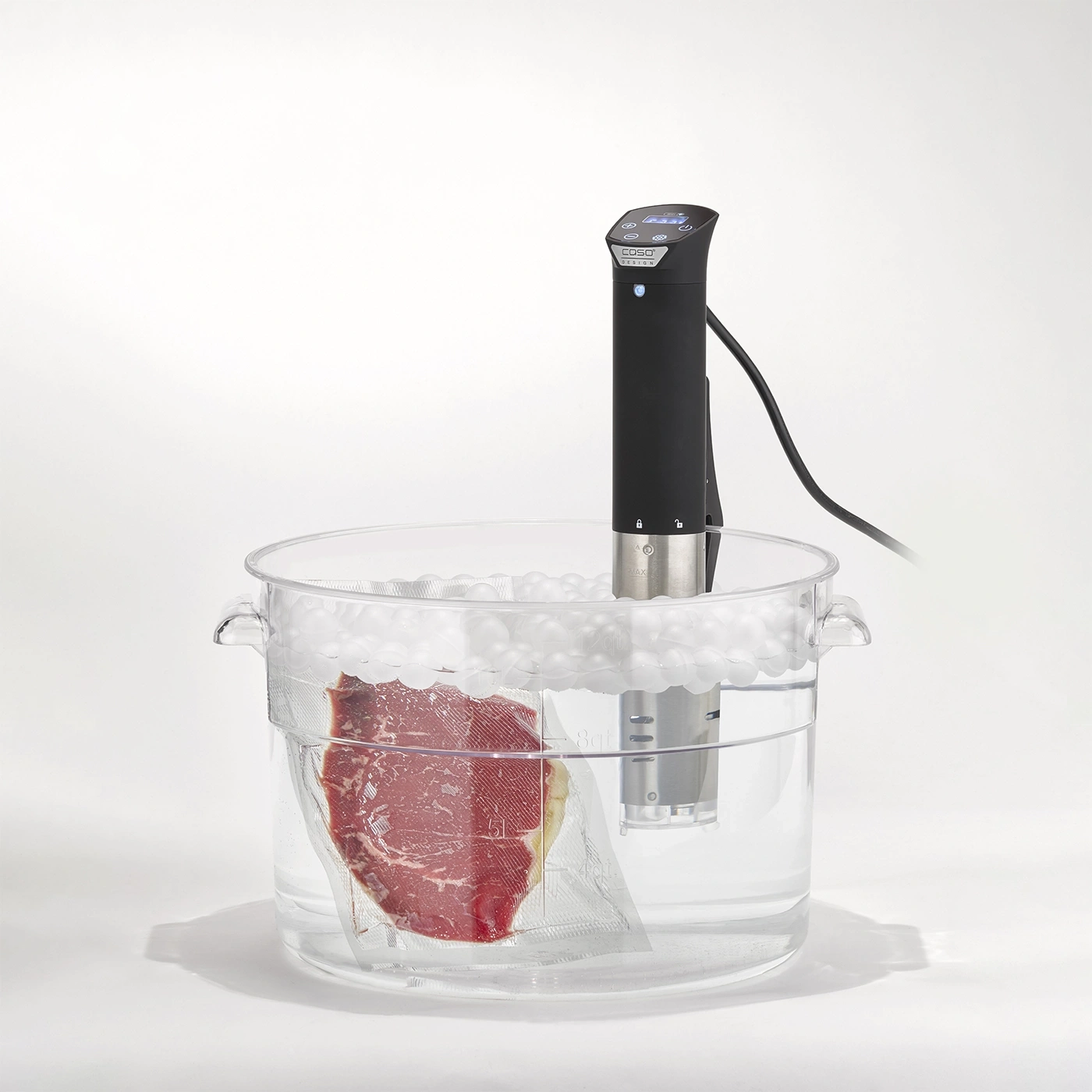 Sous-vide-Gerät gart Steak in einem Wasserbad mit Isolierkugeln.