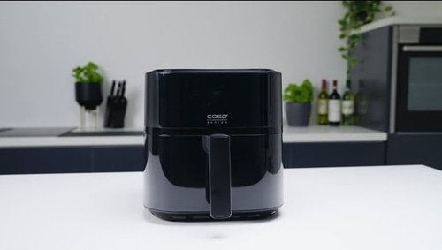 Schwarze Caso Design Airfryer auf weißem Tisch in der Küche.