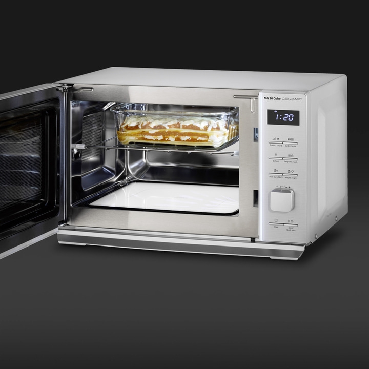 Microwave oven with food inside, open door, stainless steel, glass, lasagna, cooking