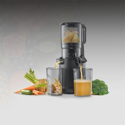 Centrifugeuse avec fruits et légumes frais, jus coulant dans des verres.