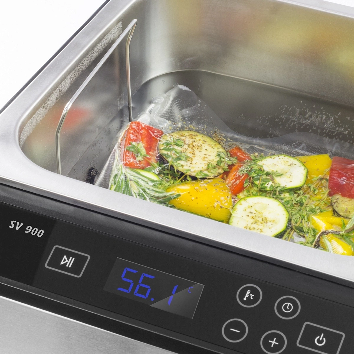 Ein Vakuumbeutel mit Gemüse in einem Wasserbad eines Sous-Vide-Geräts.