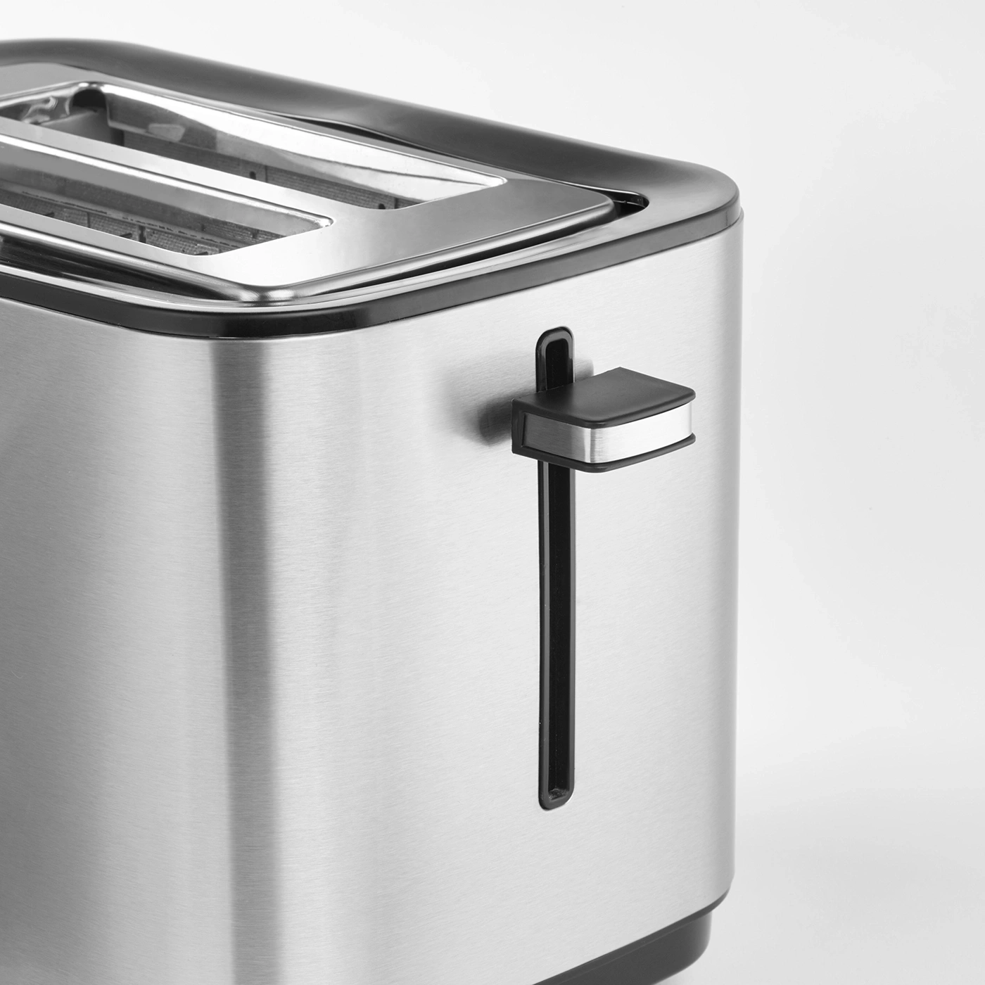 Close-up of a stainless steel toaster with a black handle and a slot for bread