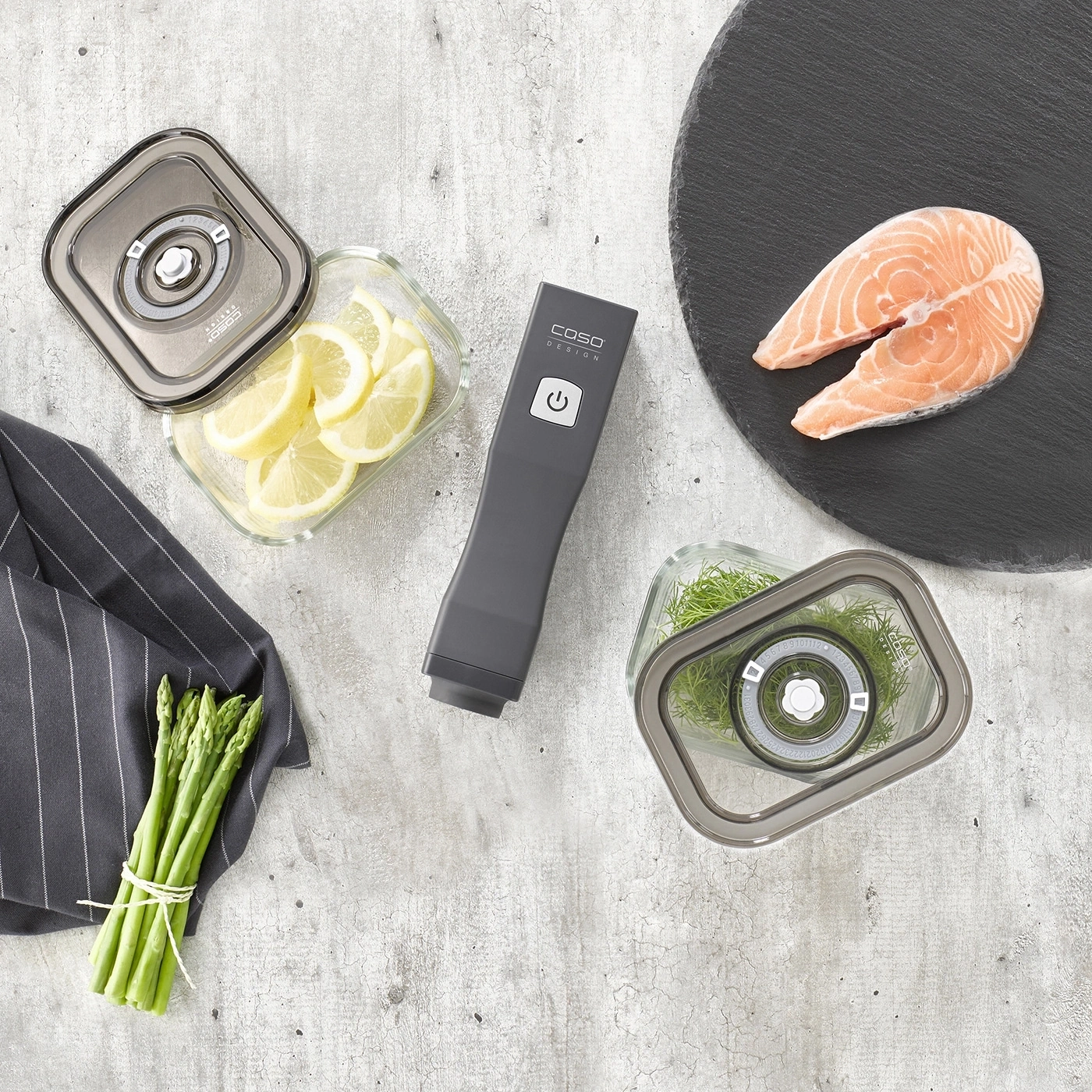 Saumon frais, citron, asperges, herbes et scelleuse sous vide sur fond gris.