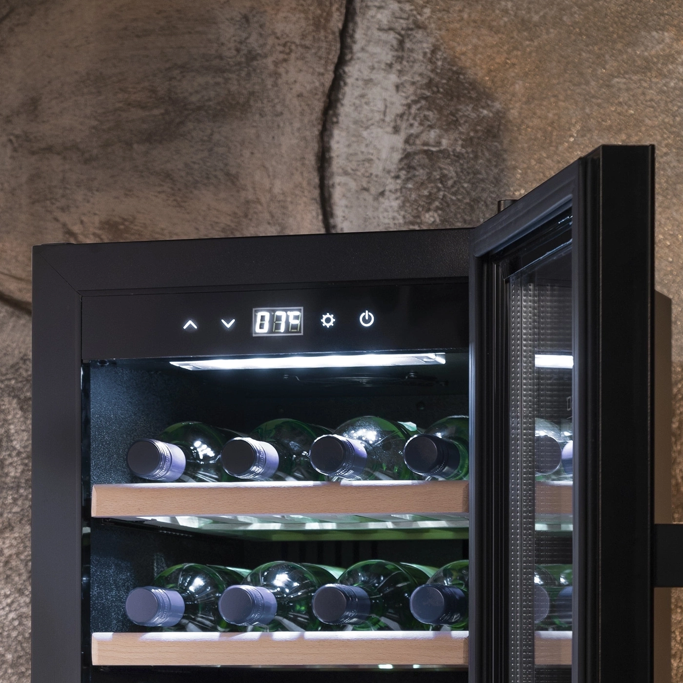 Weinkühlschrank mit geöffneter Tür, Flaschen, Temperaturanzeige, schwarzer Rahmen, Steinwand