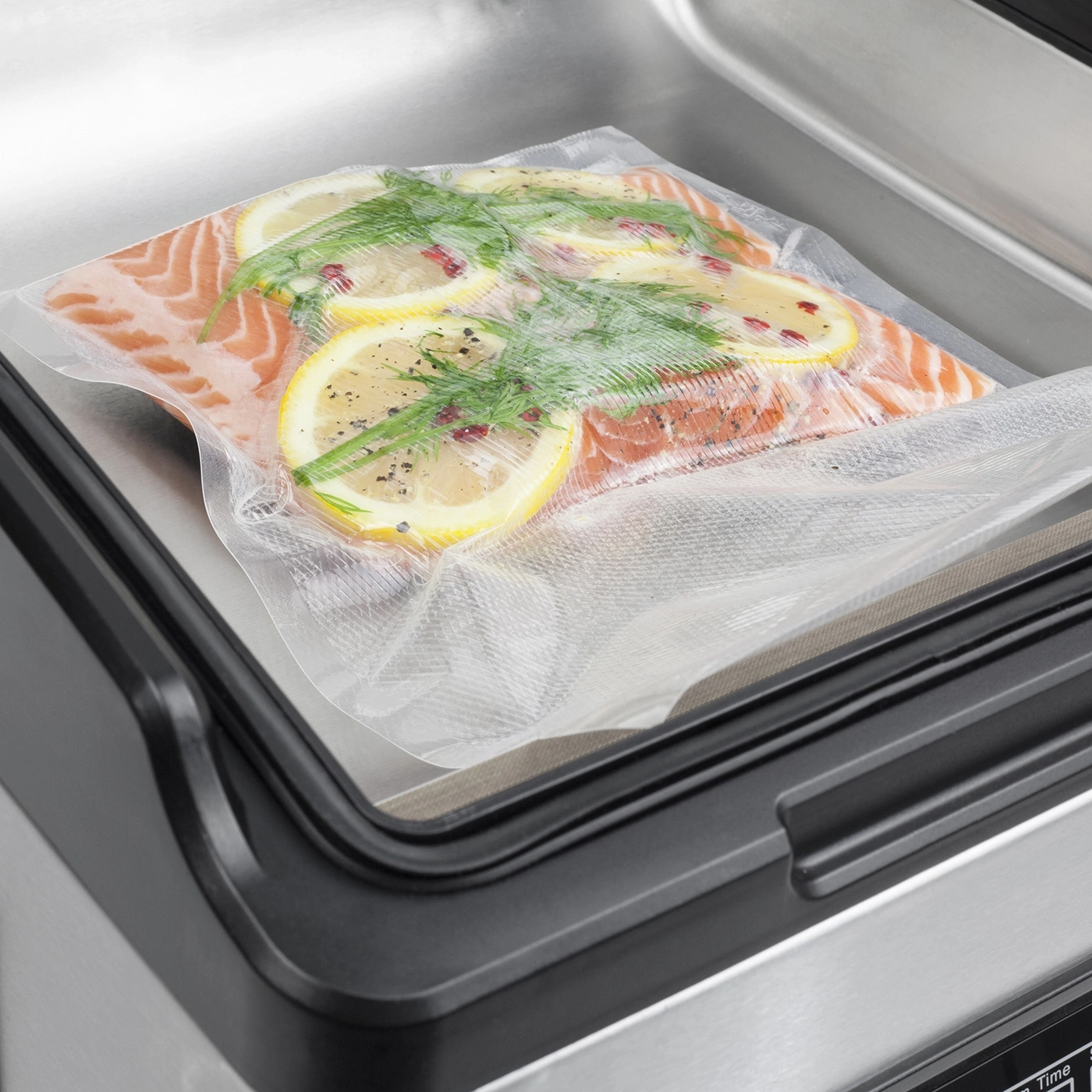 A salmon fillet with lemon and dill in a vacuum-sealed bag.