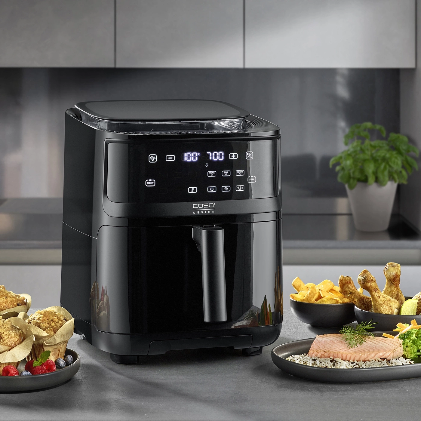 Schwarze Heißluftfritteuse mit Essen, Küche, Kochen, Mahlzeit, Gerät, Design, Caso