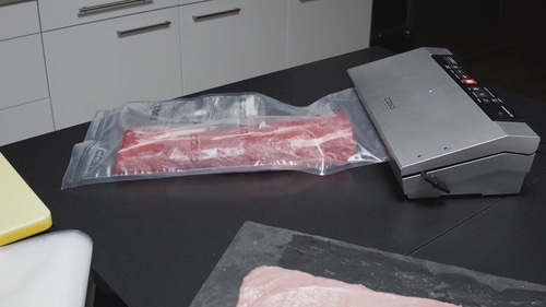 Fleisch wird mit einem Vakuumiergerät verpackt, um es zu konservieren.