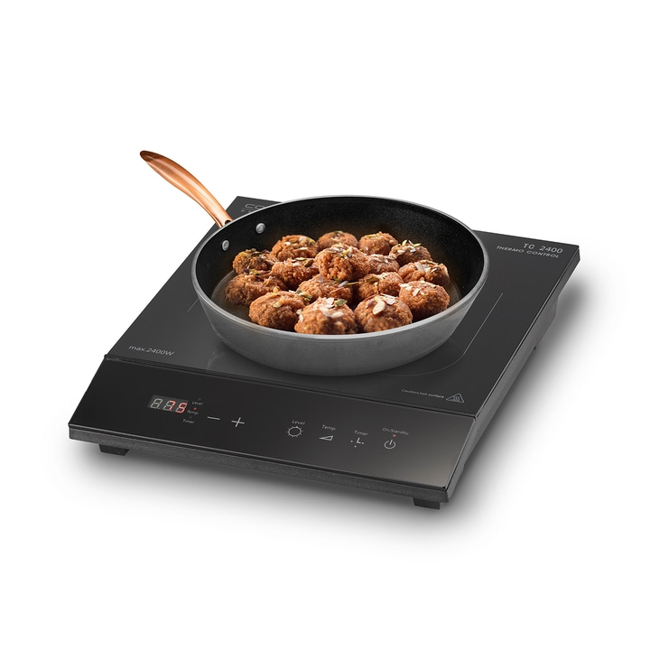 Induction cooktop with pan of meatballs, ready to cook, with control panel and display, black surface.