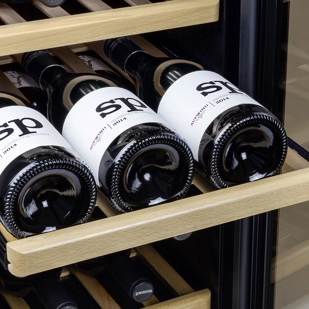 Drei Flaschen Spätburgunder Wein im Kühlschrank auf Holzregalen.