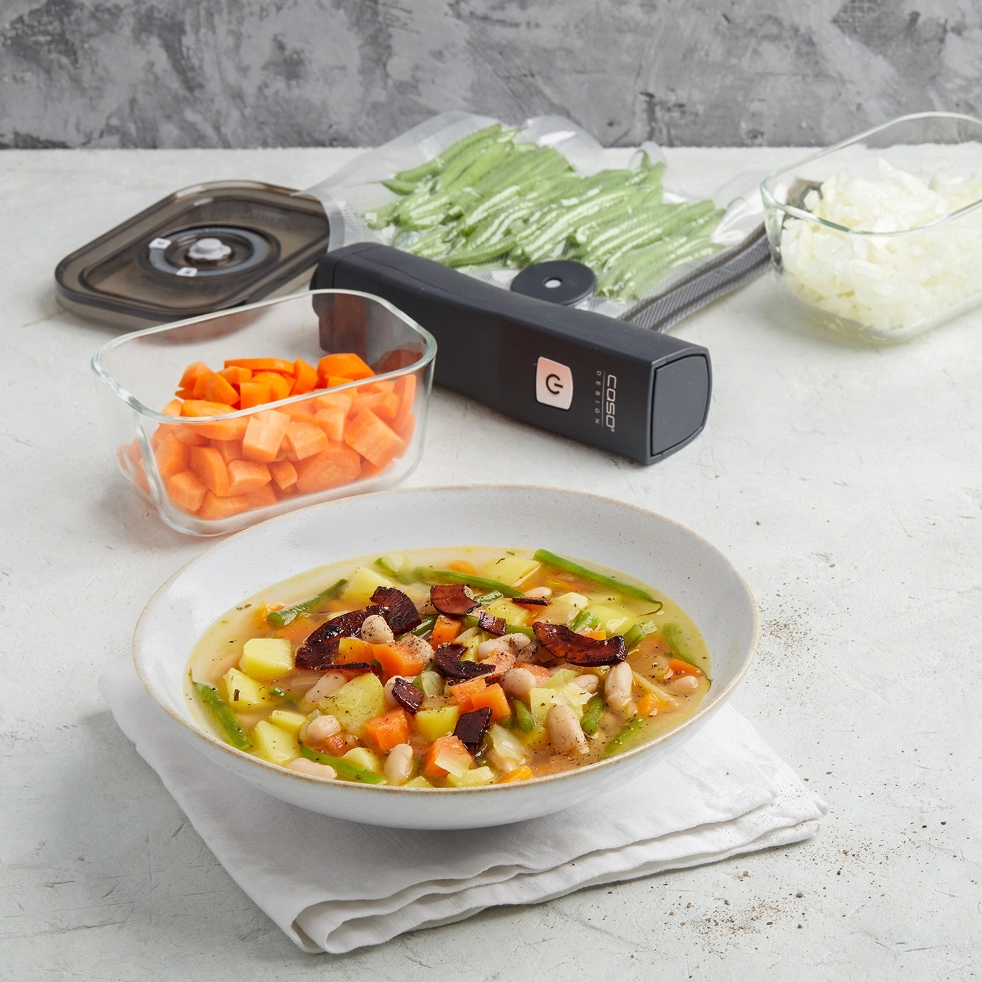 Soupe de légumes avec ingrédients, scelleuse sous vide et légumes en contenants
