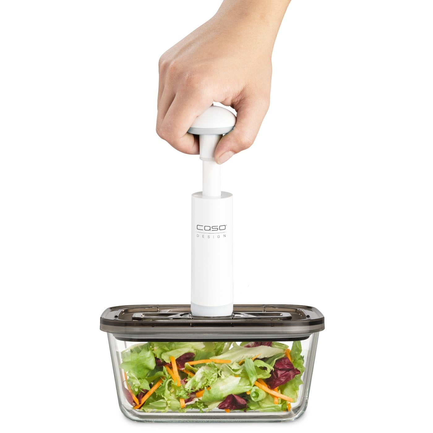 Person holding a vacuum sealer over salad in a glass container. Caso Design.