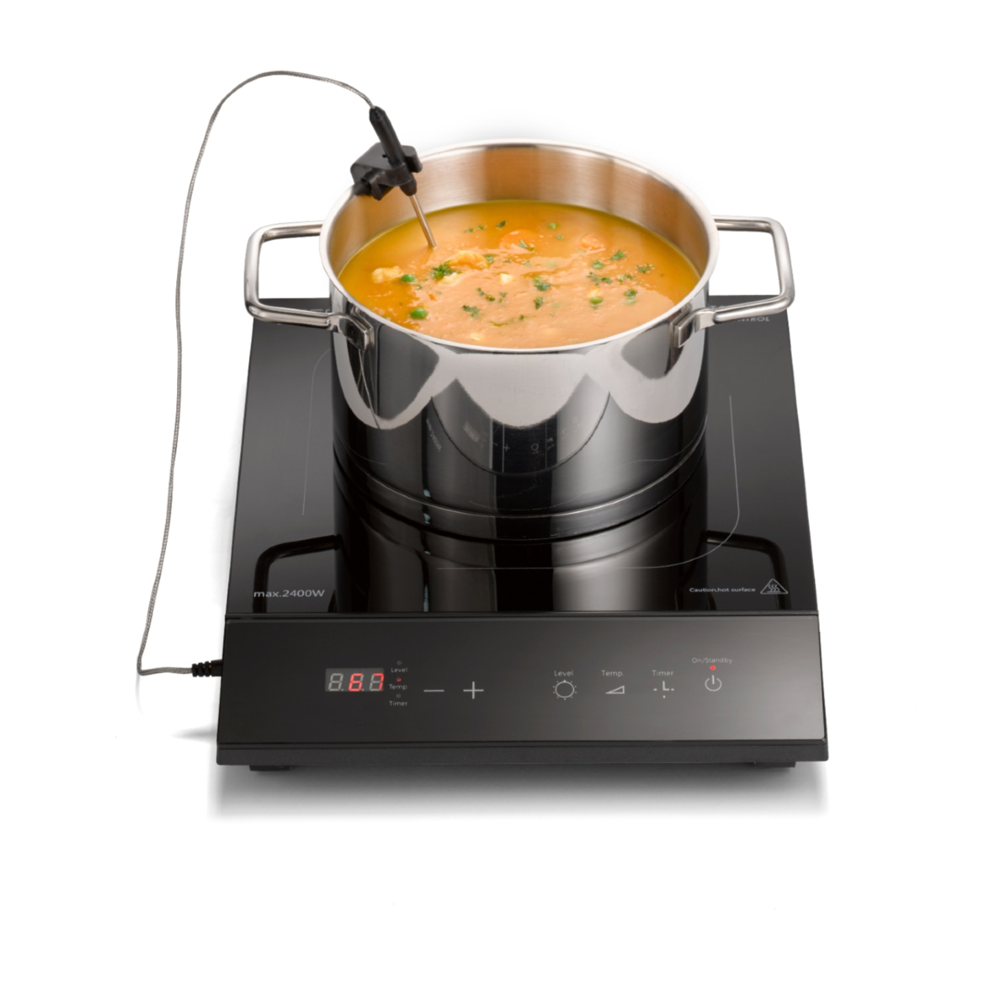 Pot of soup on induction cooktop with thermometer and control panel, cooking.