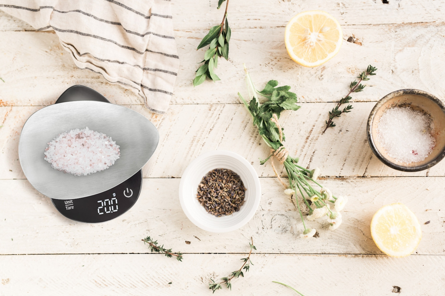 Zutaten für die Küche: Kräuter, Zitrone, Salz, Waage, Holzuntergrund, Draufsicht