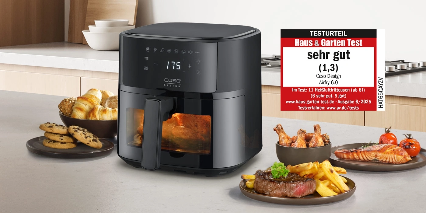 Ein schwarzer Caso Airfryer mit leckerem Essen daneben.